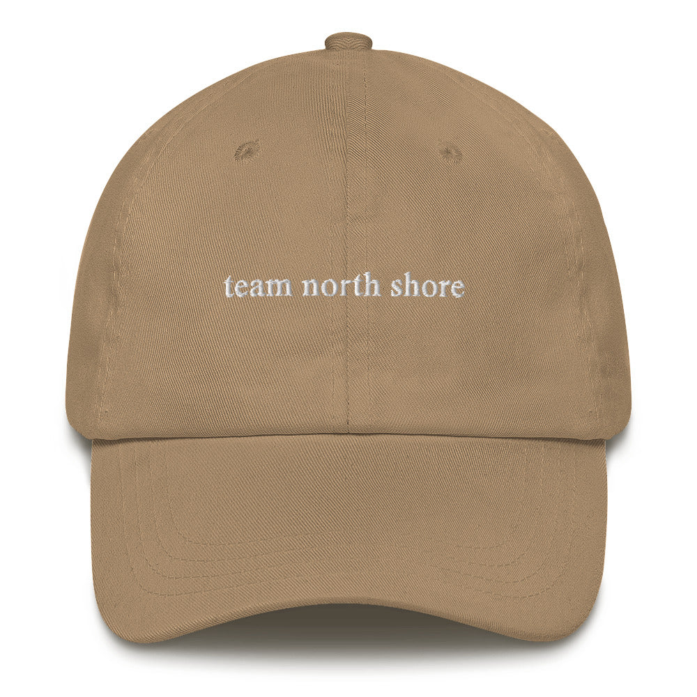 khaki baseball hat that says "team north shore" in white lettering