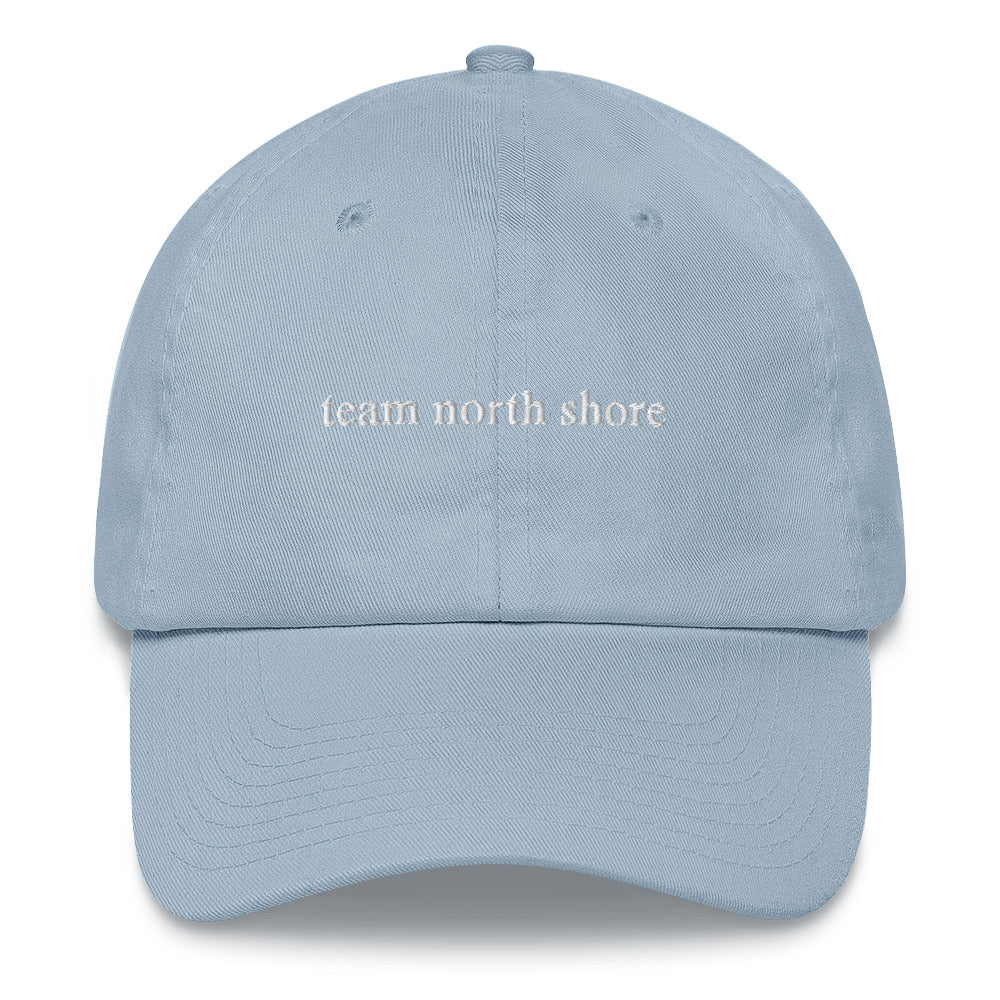 baby blue baseball hat that says "team north shore" in white lettering