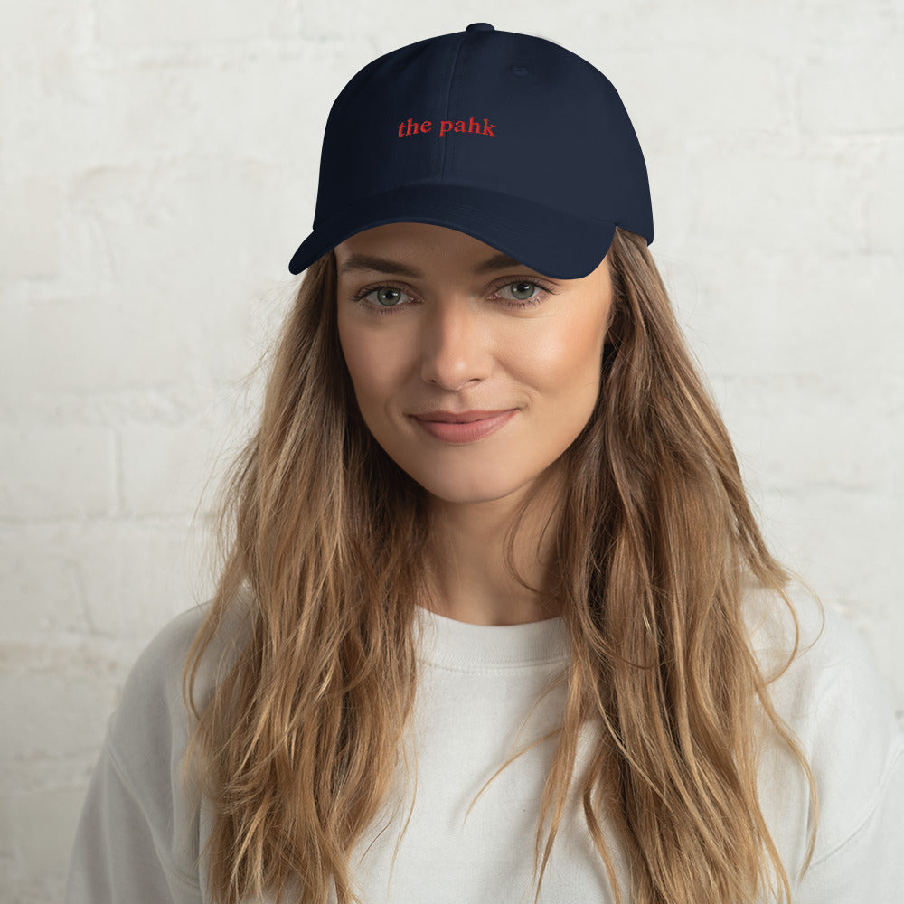 woman wearing navy blue baseball hat that says "the pahk" with red embroidery