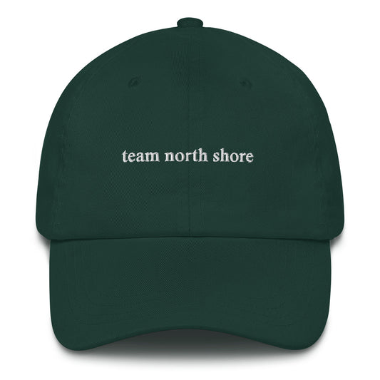 dark green baseball hat that says "team north shore" in white lettering