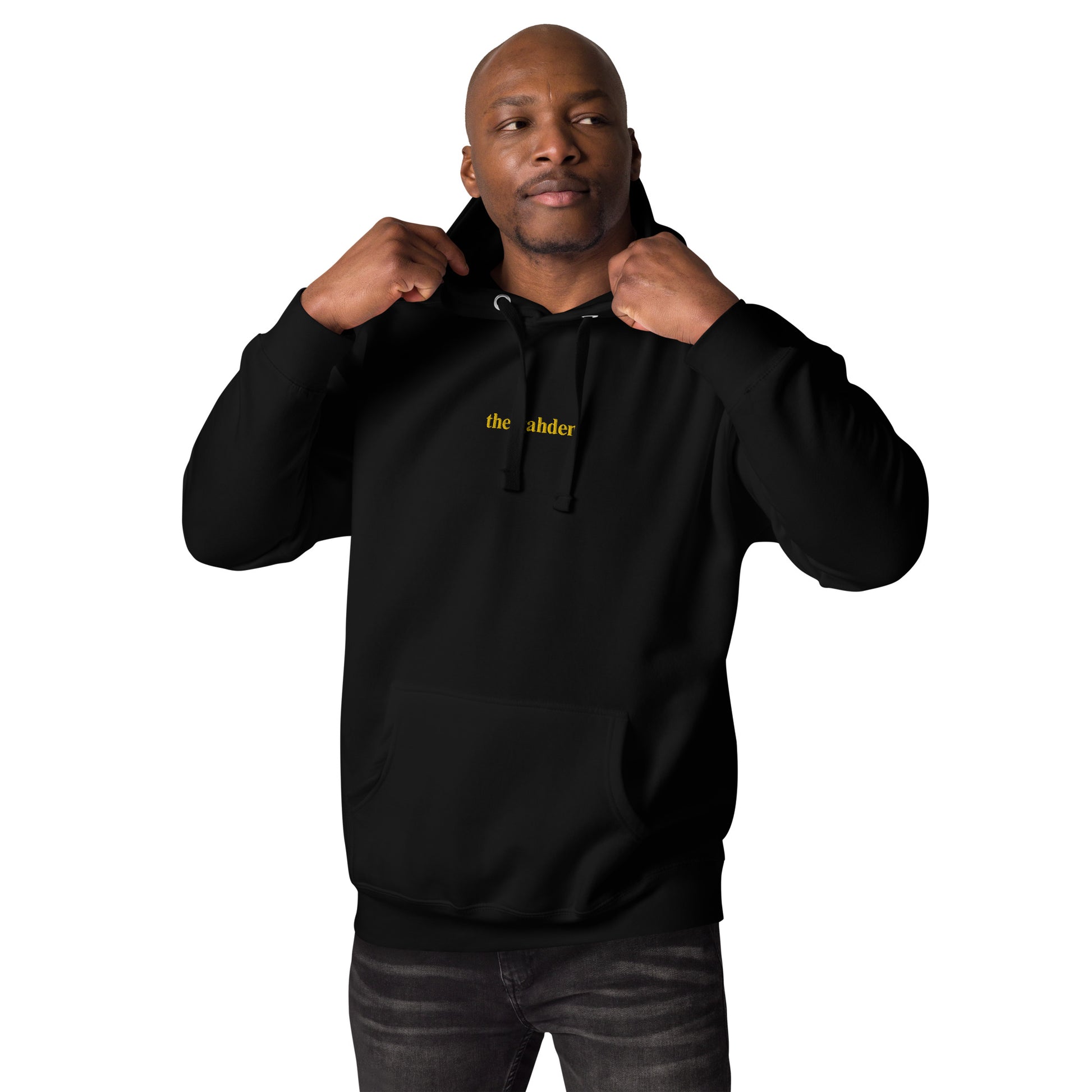  man wearing black hoodie that says "the gahden" in gold embroidery