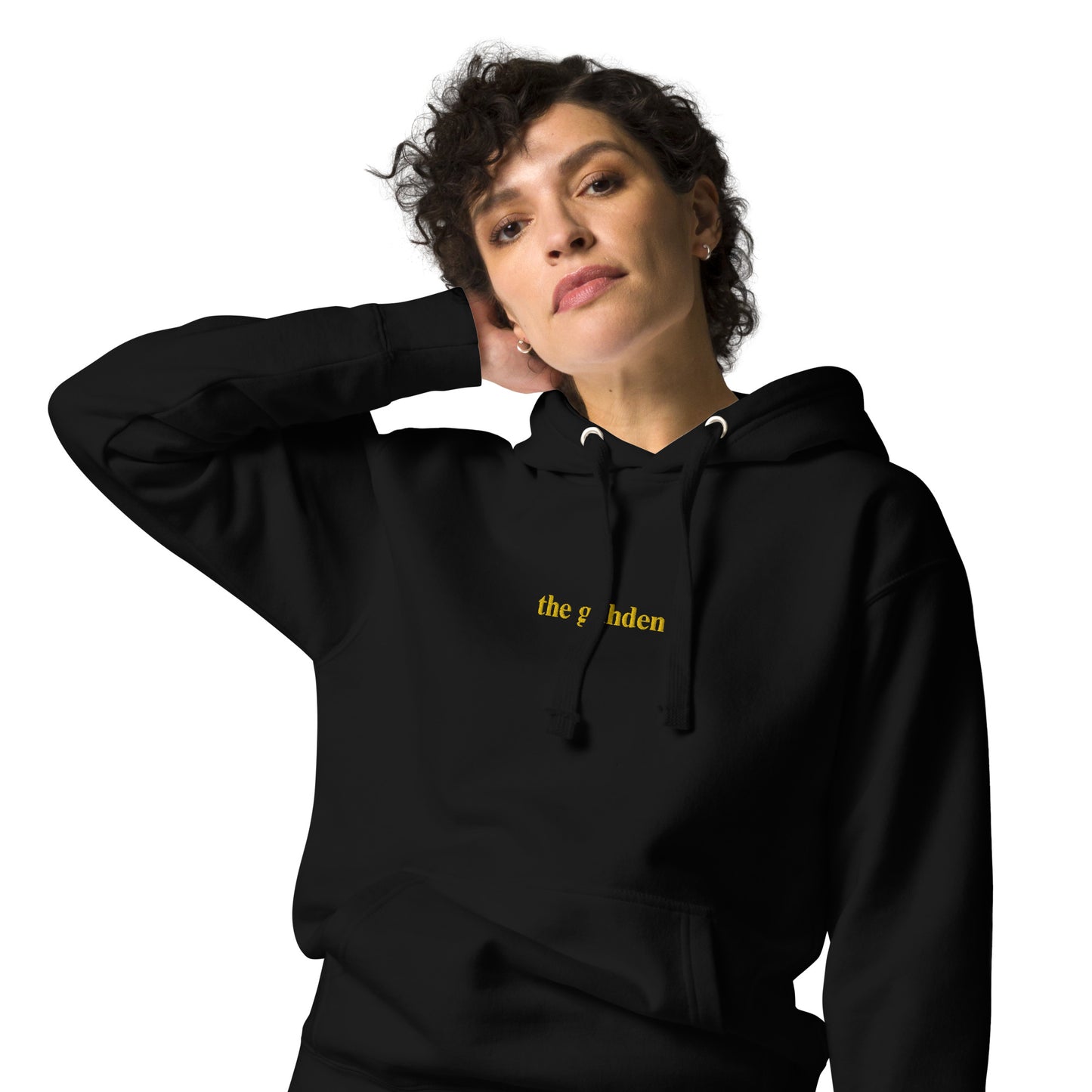 woman wearing black hoodie that says "the gahden" in gold embroidery