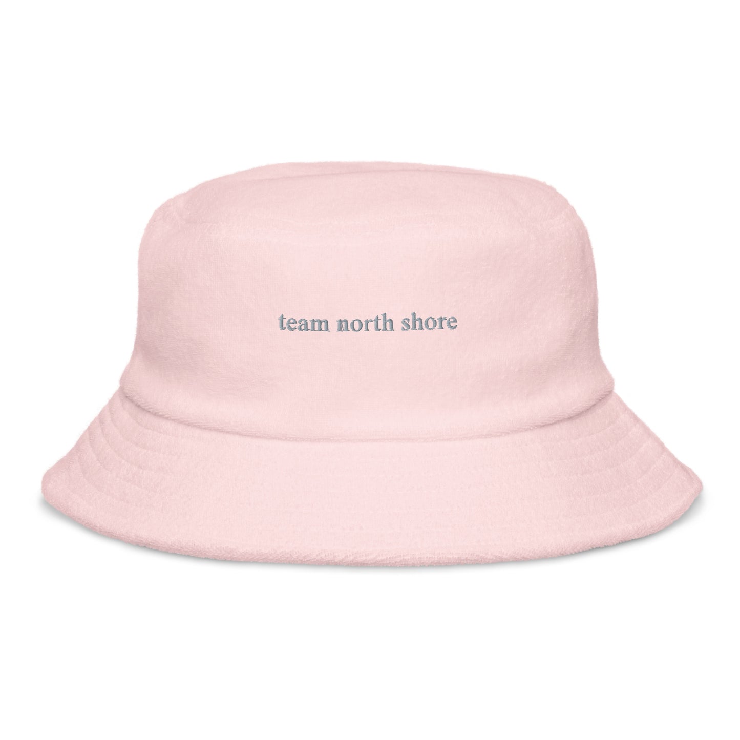 pink bucket hat that says "team north shore" in grey lettering