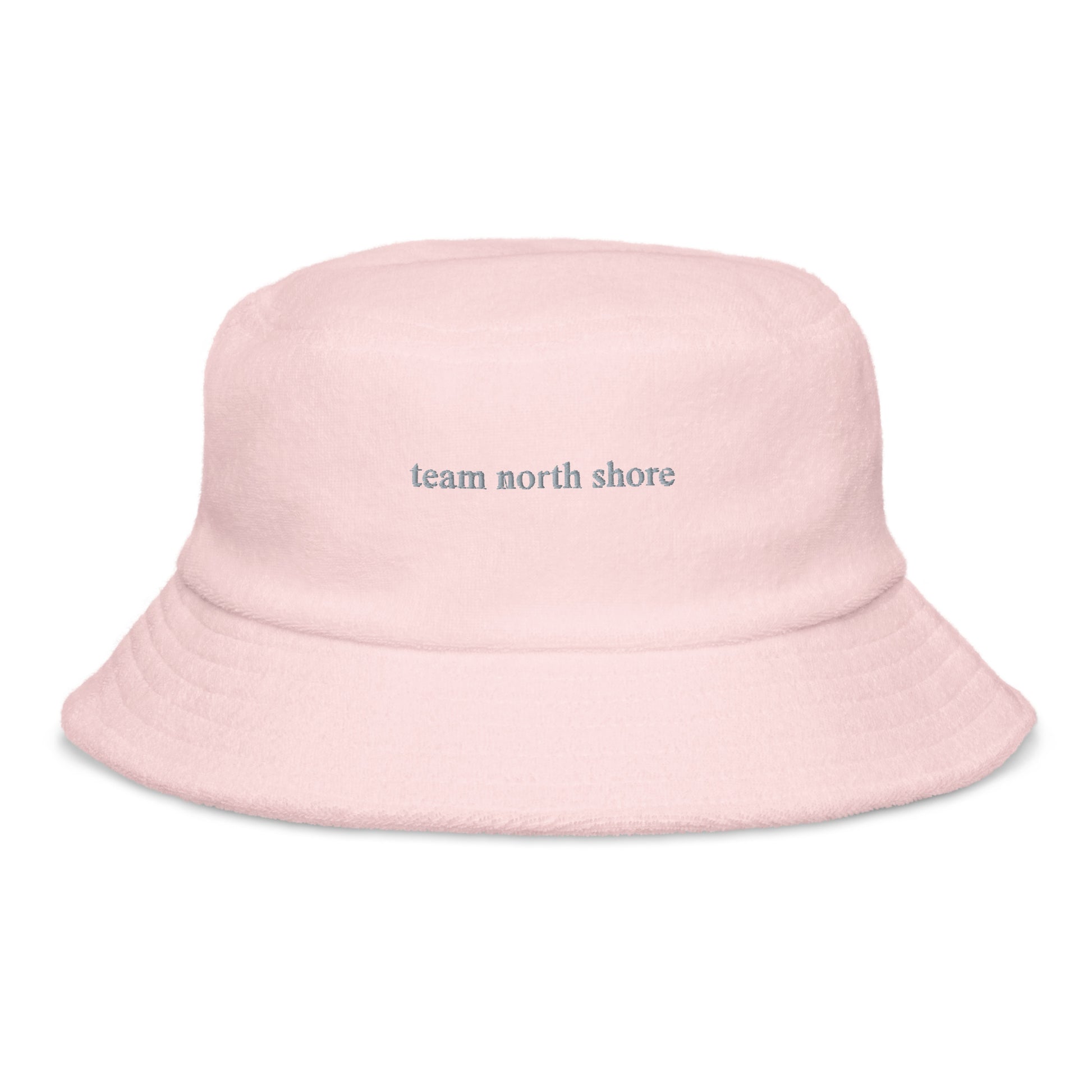 pink bucket hat that says "team north shore" in grey lettering